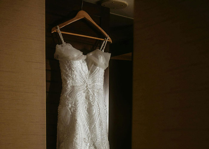 Wedding dress hanging indoors, tied to six-figure wedding budget discussion. Wedding dress hanging indoors, tied to six-figure wedding budget discussion.