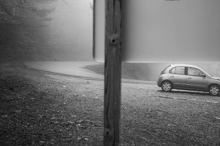 A car perfectly aligned with a road sign, creating a visual illusion; inspired by Denis Cherim's Coincidence Project.