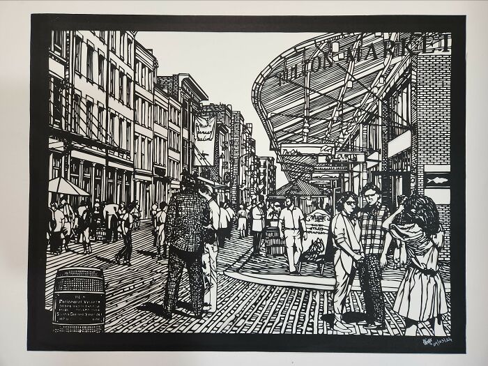 Intricate hand-cut paper artwork depicting a busy urban street scene.