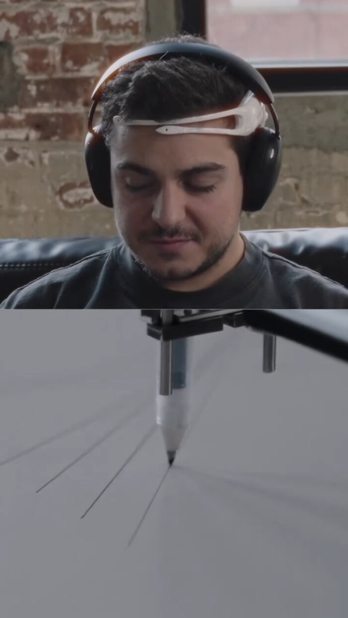 Man wears headset capturing brain activity imprint, connected to tattoo machine.