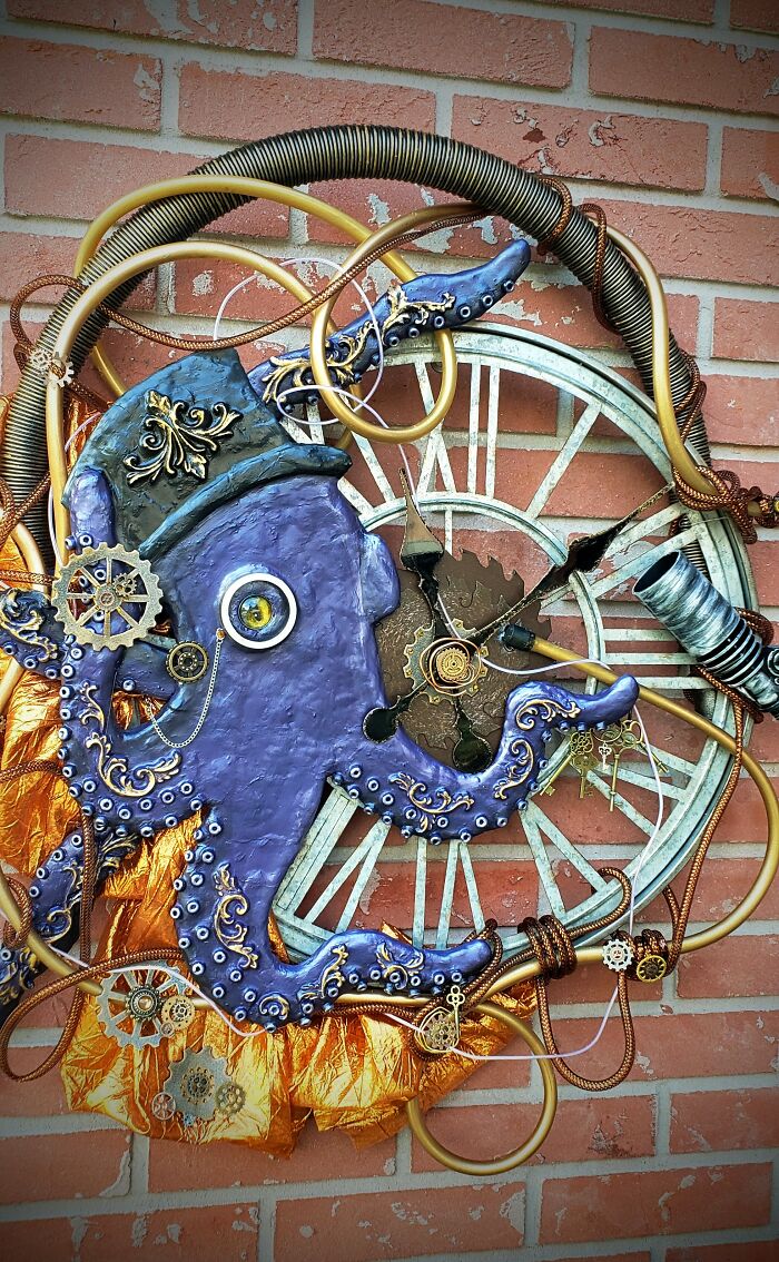 Steampunk octopus decoration with gears and pipes on a brick wall.