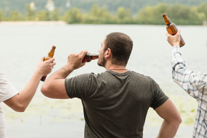 Three people by a lake, drinking beer, demonstrating non-physical qualities discussed in online forums.