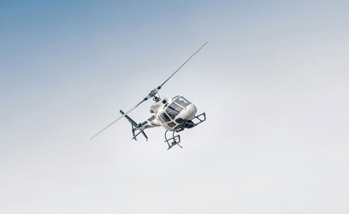 A helicopter soaring through the clear sky, symbolizing the luxury lifestyle of rich people.
