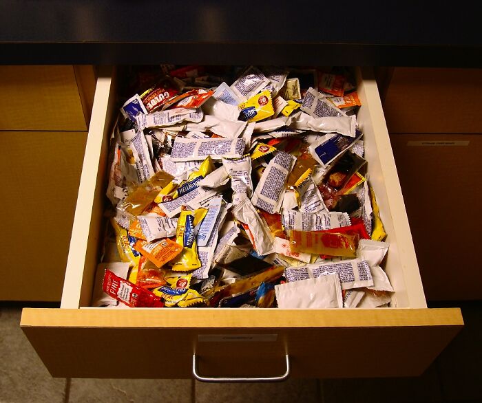 Drawer filled with assorted sauce packets, illustrating frugal storage solutions.