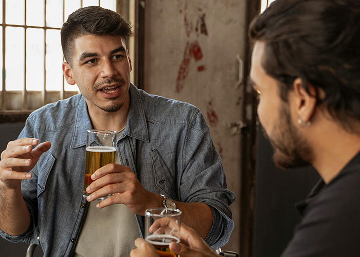 Two men talking over drinks in a casual setting, illustrating European culture shocks and differences for Americans.