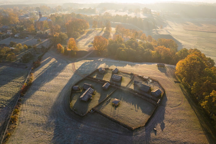 Aerial view of Lithuania showcasing scenic landscapes with autumn trees and rural buildings.