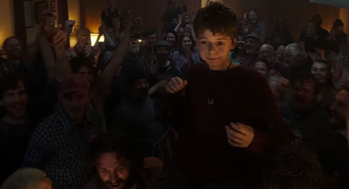 Child being lifted by cheering crowd, celebrating in a jubilant scene related to the 28 Years Later cast. Child being lifted by cheering crowd, celebrating in a jubilant scene related to the 28 Years Later cast.