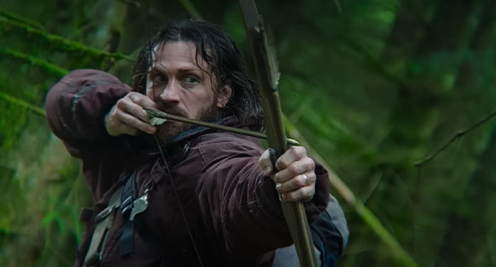 Aaron Taylor-Johnson, actor with a bow and arrow in a forest scene, related to the 28 Years Later cast. Aaron Taylor-Johnson, actor with a bow and arrow in a forest scene, related to the 28 Years Later cast.
