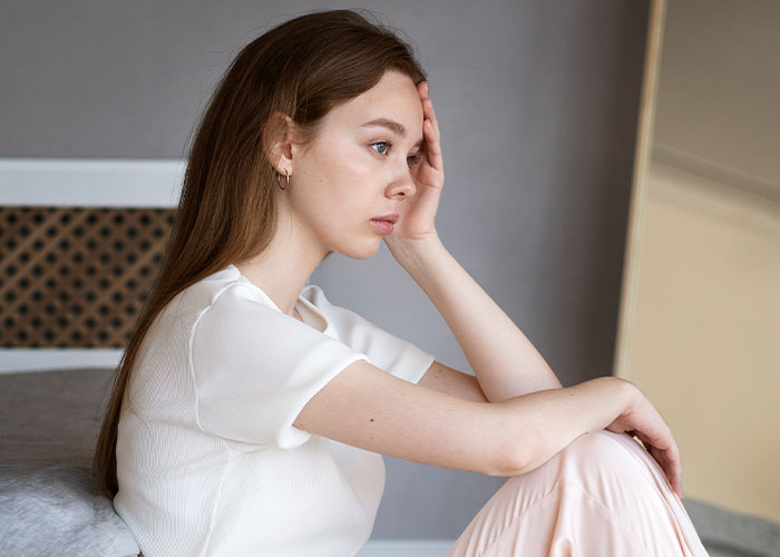 Woman in deep thought after sudden inheritance, showing true colors in relationship strain.