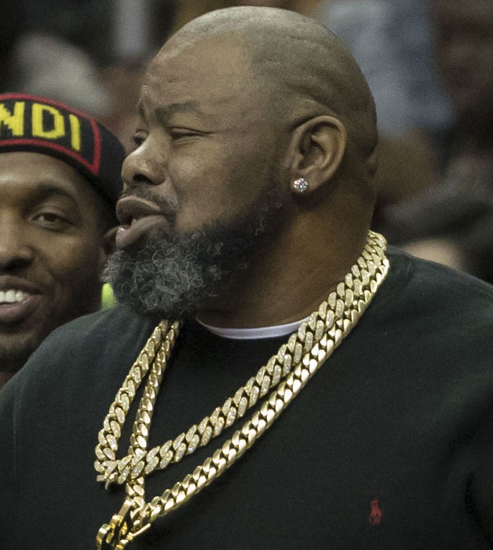 Man wearing gold chains, possibly a singer, with people questioning his musical success.