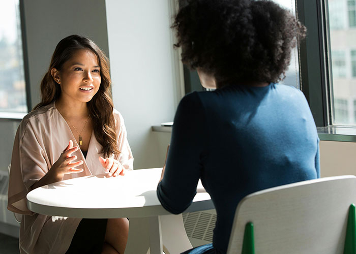 Two people having a conversation at a small table, discussing European culture shocks.