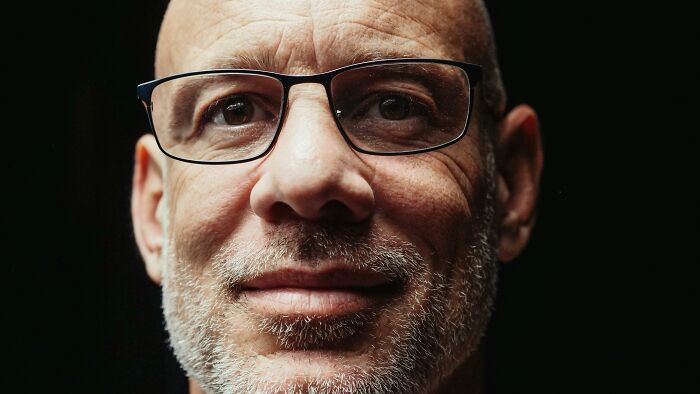 Man with glasses, reflecting on human genetic blessings and weaknesses.