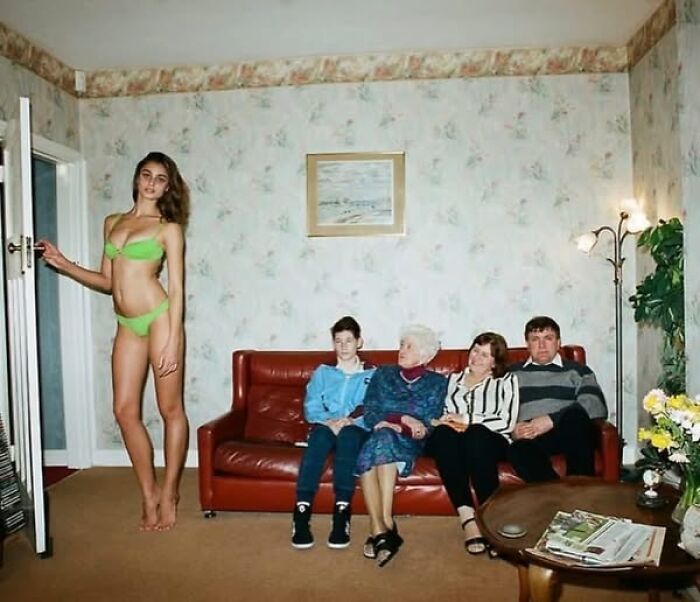 Una escena inusual con una modelo alta en bikini junto a una familia en un sofá.