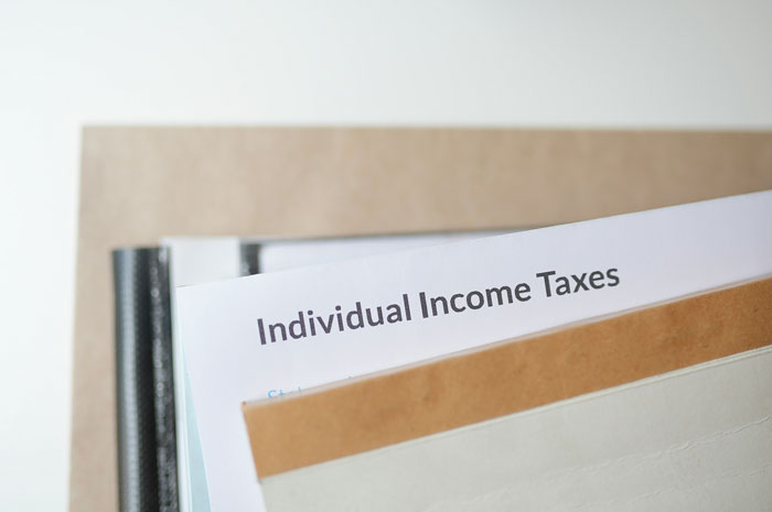 Individual income taxes documents in folders, depicting a financial concept with a focus on wealth perception.