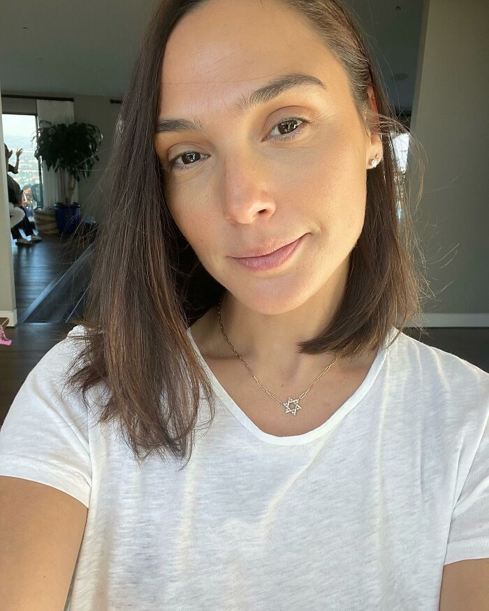 A person in a white shirt, close-up, standing in a well-lit room, showcasing celebrity insights.