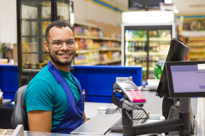 Cashier in a grocery store, representing common USA things that might confuse foreigners.