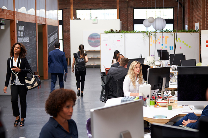 Women working in an open-plan office, interacting and focusing on tasks in a professional environment. Women working in an open-plan office, interacting and focusing on tasks in a professional environment.