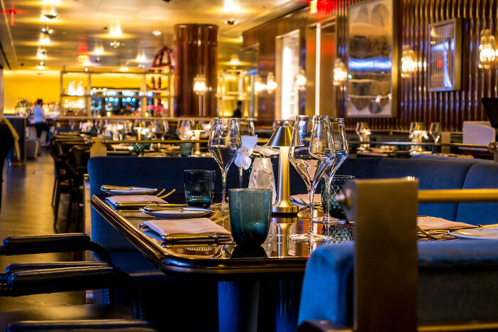 Luxury dining table set with glassware, napkins, and elegant decor in an upscale restaurant associated with rich people.