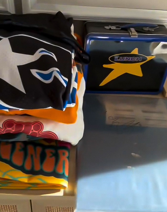 A lunchbox with a star and folded clothes on a table, associated with charity and self promotion.