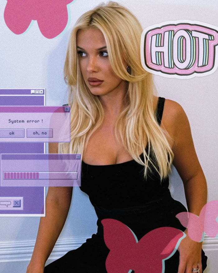 Blonde woman in a stylish black dress with graphic elements, showcasing a bold new look.