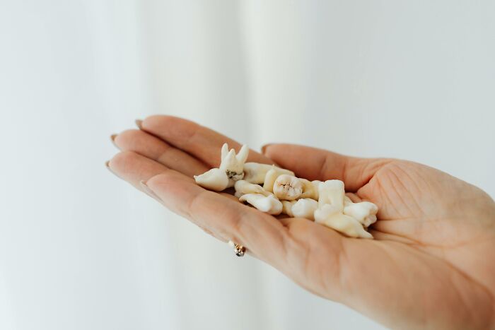 A hand holding several human teeth, symbolizing weird flags in people.