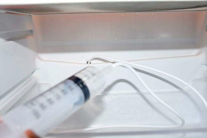 Syringe and tubing inside a refrigerator, part of a spring cleaning headstart.