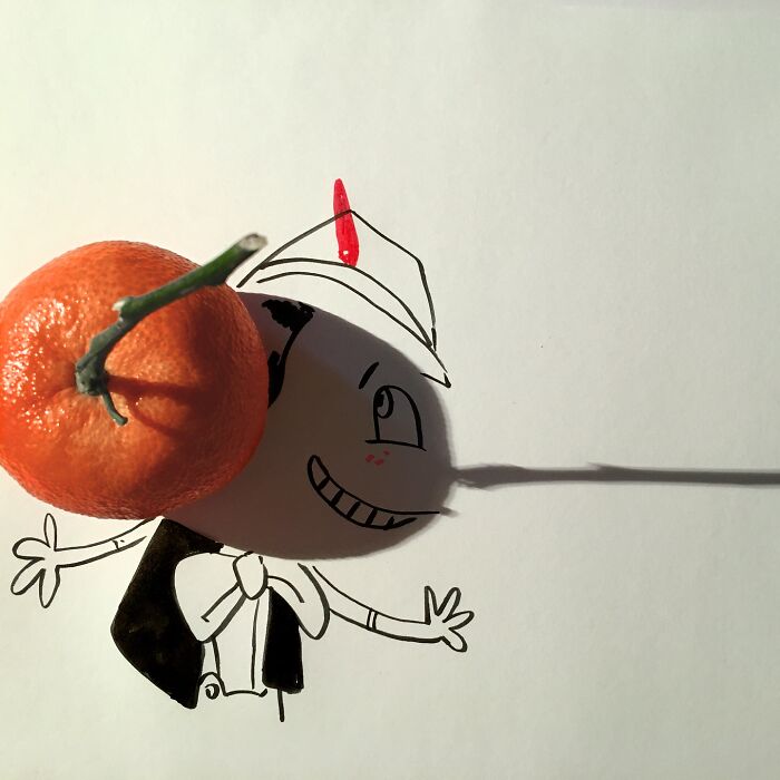 Artist turns object shadows into playful illustrations using a tangerine as a character's head.