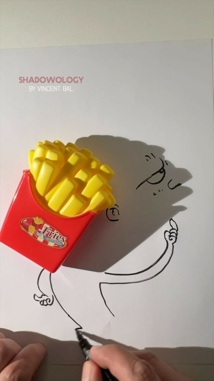 Artist illustrating shadow of toy fries into a playful character drawing.
