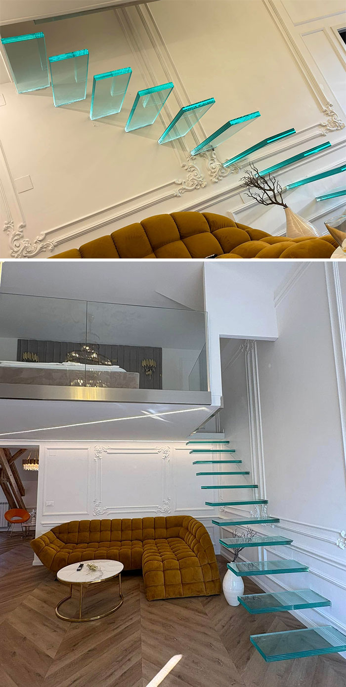 Glass "death stairs" with floating steps in a modern living room, featuring a mustard sofa and minimalist decor.