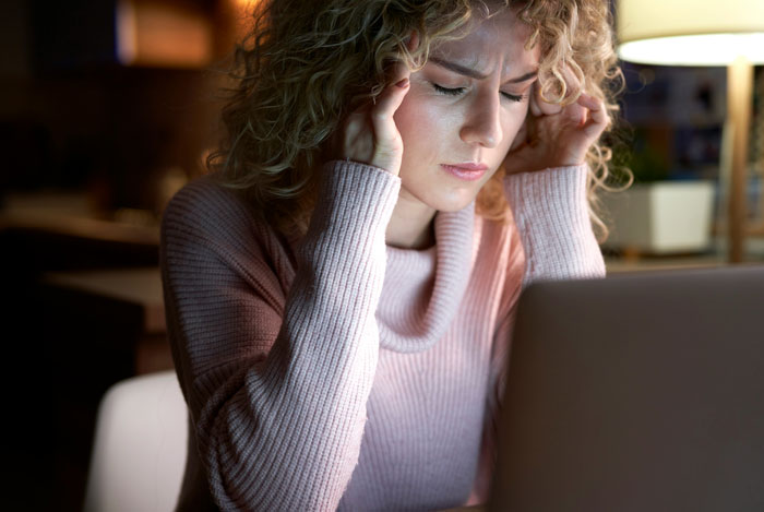 Woman looking frustrated at her laptop, expressing dissatisfaction. Woman looking frustrated at her laptop, expressing dissatisfaction.