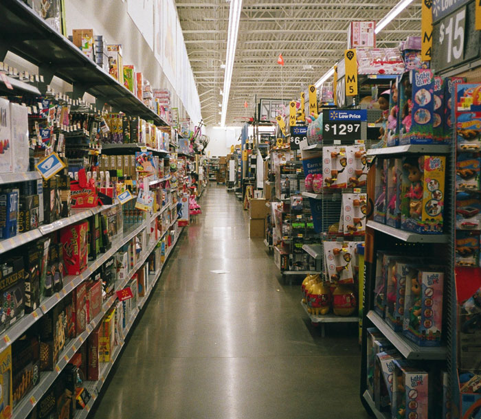 Pasillo de supermercado con juguetes y artículos variados en estantes.