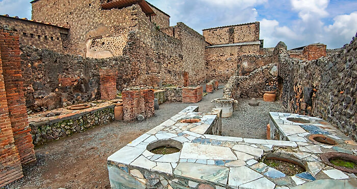 Ancient ruins showcasing old stone structures under a cloudy sky, highlighting fascinating historical facts.