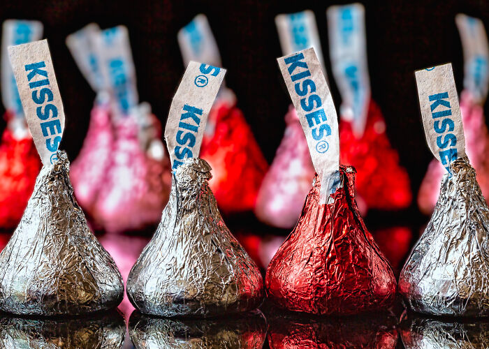 Silver and red foil-wrapped chocolate kisses, perfect simple Valentine’s gift idea, arranged in rows.