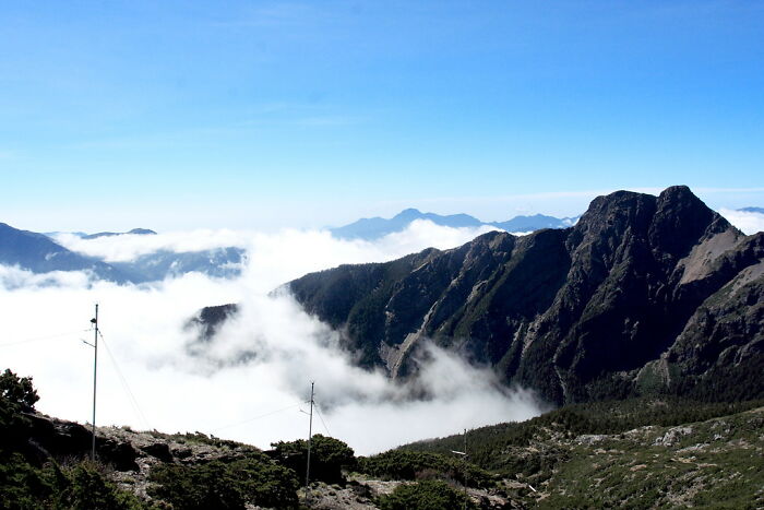 Mountain peaks rising above clouds, showcasing breathtaking natural wonders.