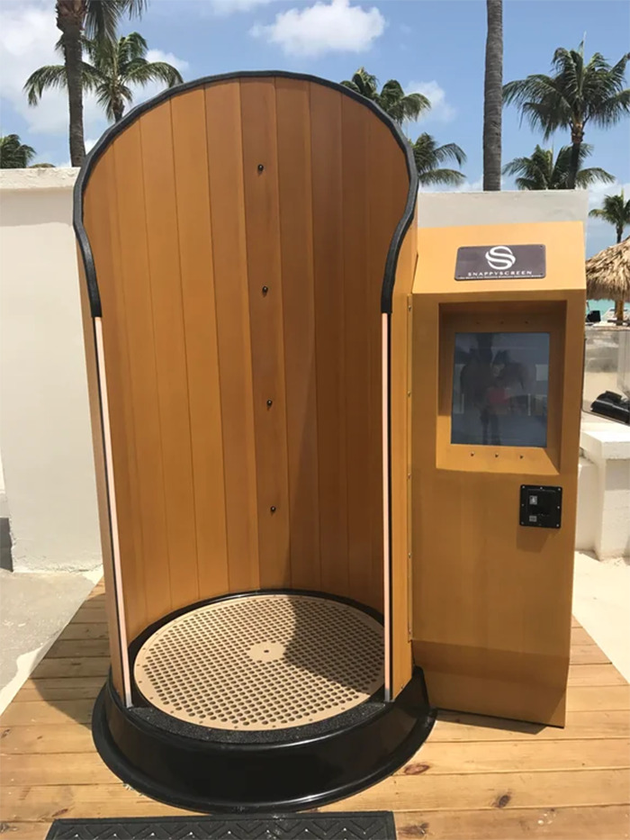 Outdoor shower kiosk with innovative design under palm trees, showcasing Cities-Genius-Solutions.
