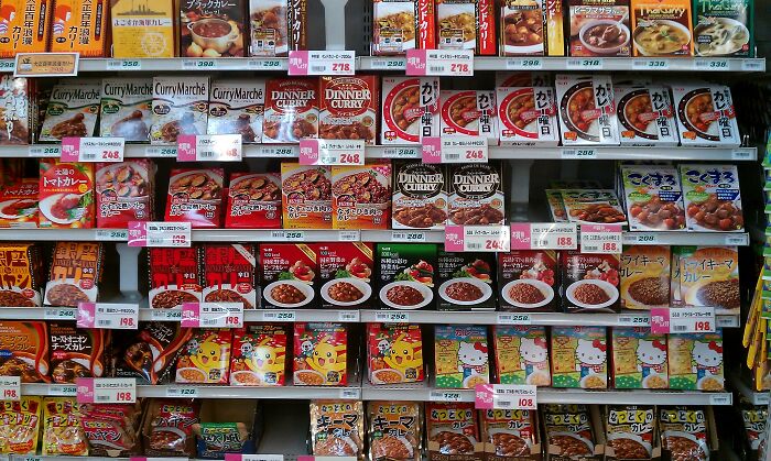 Grocery aisle with a variety of Japanese curry packages, highlighting culture shocks in international supermarkets.