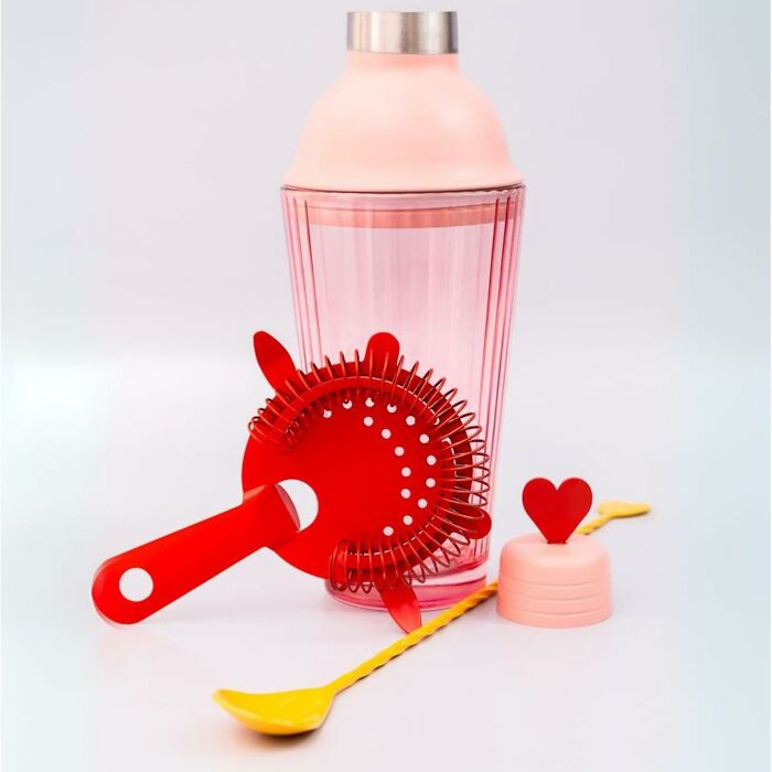 Bando cocktail shaker set with pink and red accessories, including a strainer, heart stopper, and yellow spoon.