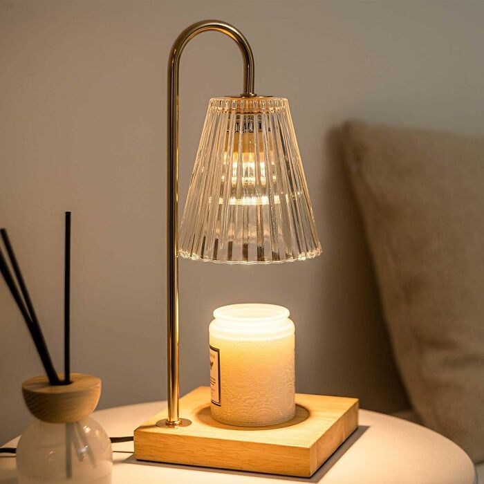 Elegant lamp and candle decor on a table, showcasing useful things that also look nice.