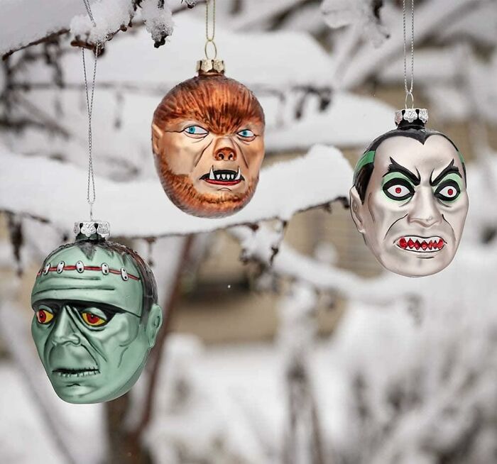 Ornaments shaped as classic monsters hanging on a snowy branch, featuring Archie Mcphee items.