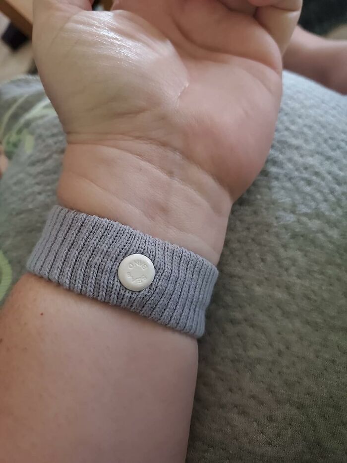 A gray wristband worn on a wrist, designed to simplify daily life with problem-solving features.