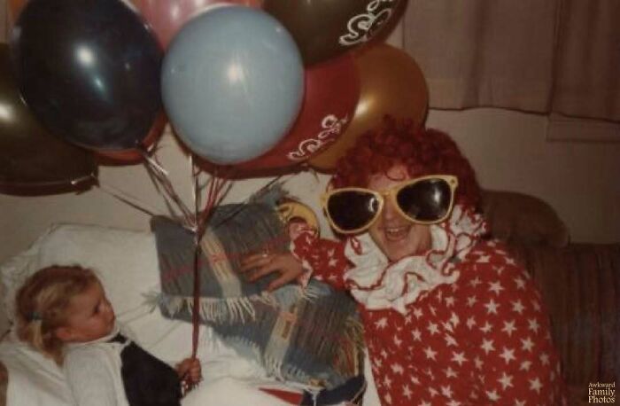 Child holding balloons next to a person in oversized sunglasses and red star costume in awkward family photos that feel sweet.