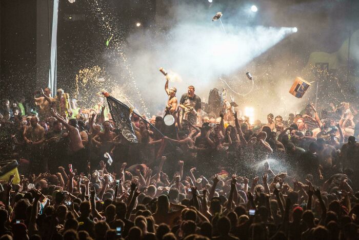 Energetic crowd scene with partygoers and spotlights, resembling an accidental Renaissance painting.