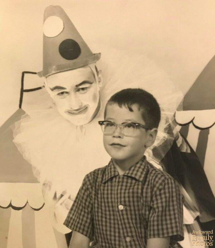 Black and white photo of a vintage awkward family moment with a man in clown makeup and a boy wearing glasses.