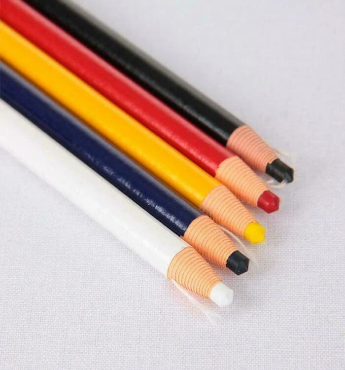 Colorful, vintage retractable pencils arranged on a white surface, evoking nostalgia.