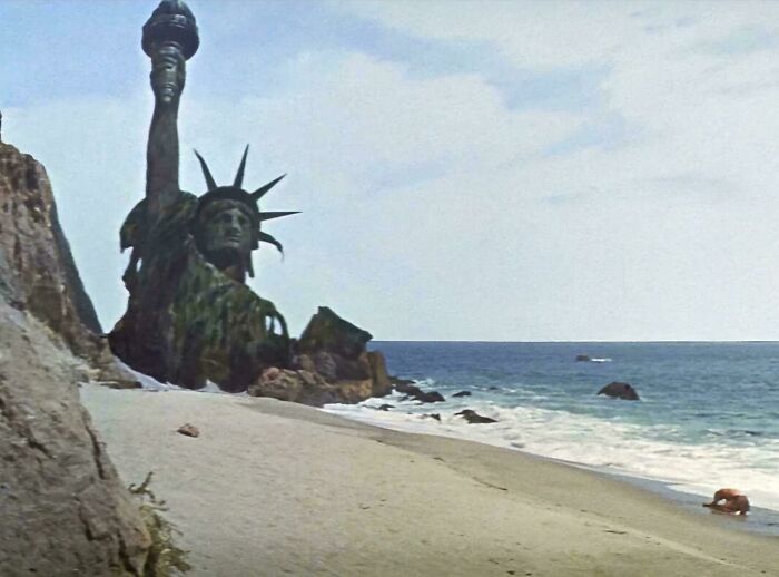 Statue of Liberty half-buried on a beach in a classic movie scene highlighting questionable movie details mocked by cinephiles.