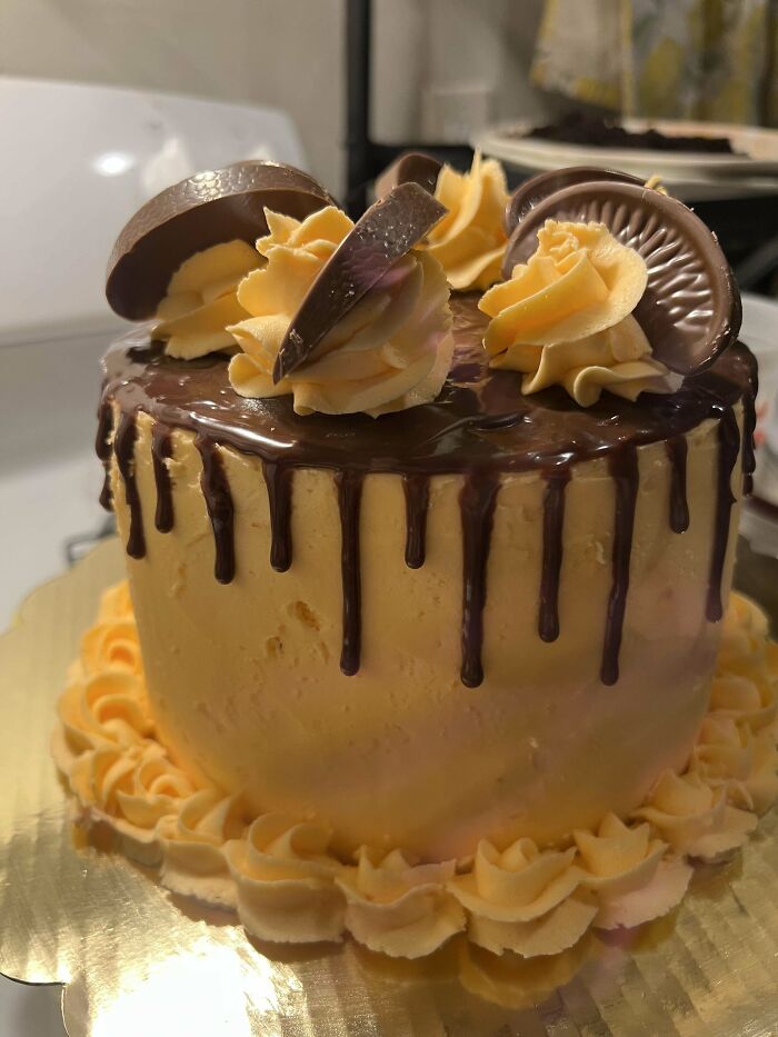 Chocolate drip cake with peanut butter frosting and decorative swirls, an incredible bake deserving all the spotlight.