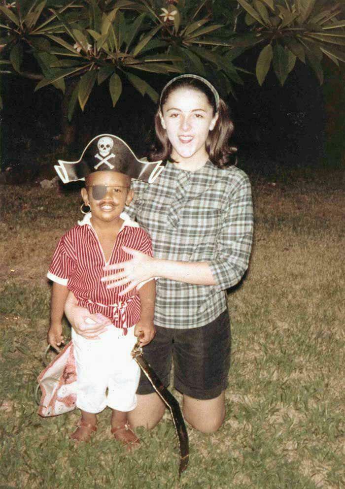 "Child in pirate costume with an eye patch, standing with a woman outdoors, showcasing rare historical moments."