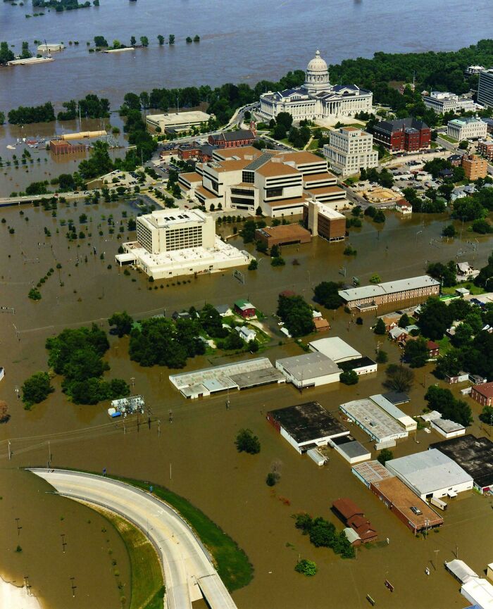 Historic aerial view of severe floodwaters submerging buildings and streets, illustrating rare historical events.