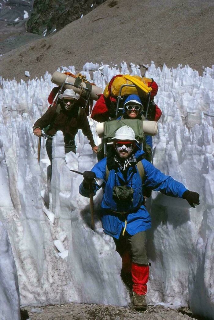 Climbers equipped with gear navigating icy terrain, showcasing rare historical exploration.