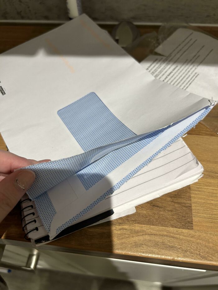 "Messy desk with envelopes and papers, likely left by terrible neighbors, creating a cluttered and frustrating scene."